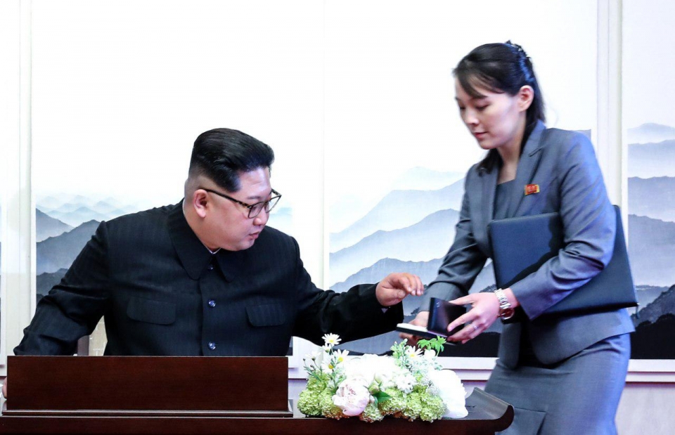 김정은 위원장이 방명록 서명에 앞서 김여정 제1부부장에게서 펜을 건네받고 있다.