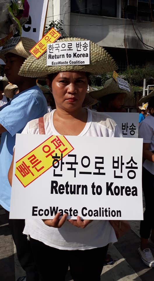시민들은 피켓과 모자에 영어와 한국어로 플라스틱 쓰레기 반환을 요구하는 문구를 붙이고 가두행진을 벌이고 있다.