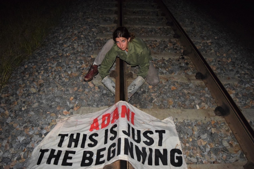 지난 1일 호주 환경보호단체 소속 마크 심슨이 양 팔을 철로에 고정해 석탄 수송 열차를 막고 있다. (사진 ERA 제공)