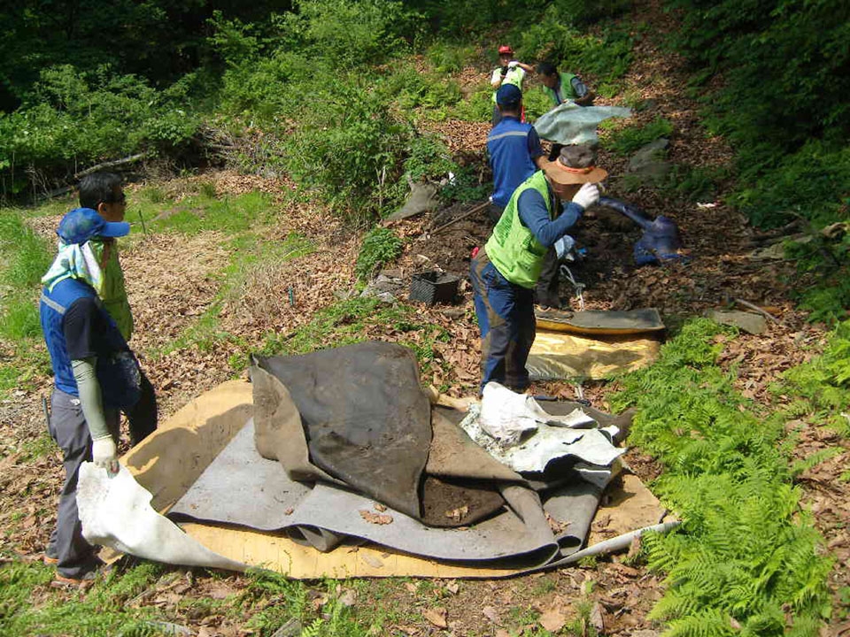 산속 땅에 묻힌 쓰레기를 파내 수거하는 모습. (사진=성남시 제공)