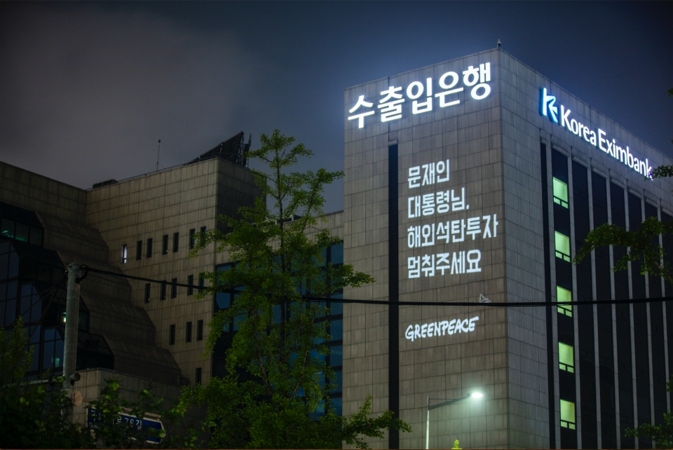 국제환경단체 그린피스 서울사무소가 6월 30일 저녁 여의도 수출입은행 건물에 레이저빔을 투사해 '문재인 대통령님, 해외석탄투자 멈춰주세요' 등의 메시지를 새겼다. (사진 그린피스 제공)