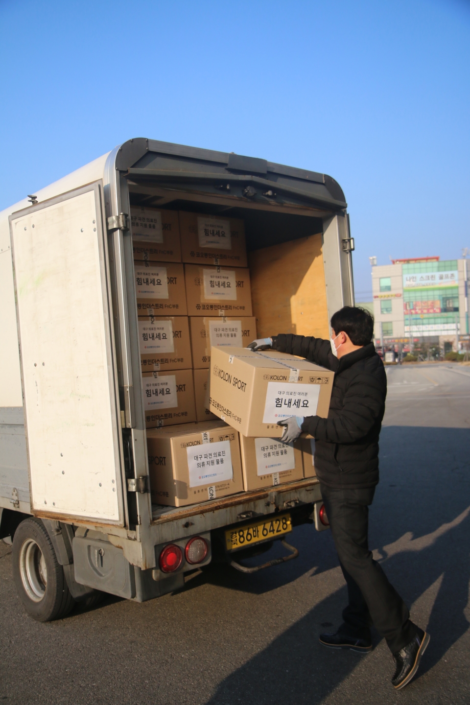 코오롱FnC 직원이 대구에 파견된 공중보건의들에게 전달할 의류를 배송차량에 싣고 있다. (코오롱FnC 제공) 2020.3.10/그린포스트코리아