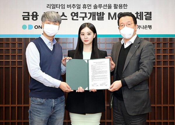 하나은행은 지난 13일 오후 서울 중구 을지로 하나은행 본점에서 버추얼 휴먼 솔루션 기업 온마인드와 전략적 업무협약을 체결했다. 사진은 황보현우 하나은행 데이터&제휴투자본부 본부장(오른쪽), 김형일 온마인드 대표이사(왼쪽), 가상인간 나수아가 기념촬영을 하고 있다.(하나은행 제공)/그린포스트코리아