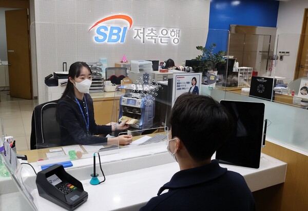 SBI저축은행 청담직원 직원이 소독된 지폐를 고객에게 전달하고 있는 모습.(SBI저축은행 제공)/그린포스트코리아