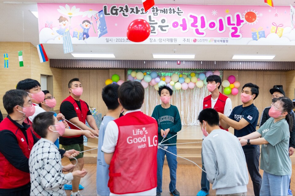 어린이날을 맞아 서울 암사재활원에 거주하는 장애 아동·청소년들을 위한 '오늘은 어린이날' 행사를 가진 LG전자. 사진은 LG전자 직원들과 장애아동들이 협동 공던지기를 하는 모습(사진=LG전자)/그린포스트코리아