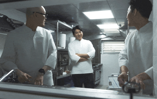 래코드의 셰프복을 입은 안성재 모수 서울 오너 셰프(가운데)와 직원들이 주방에서 일하고 있다./코오롱FnC 제공 