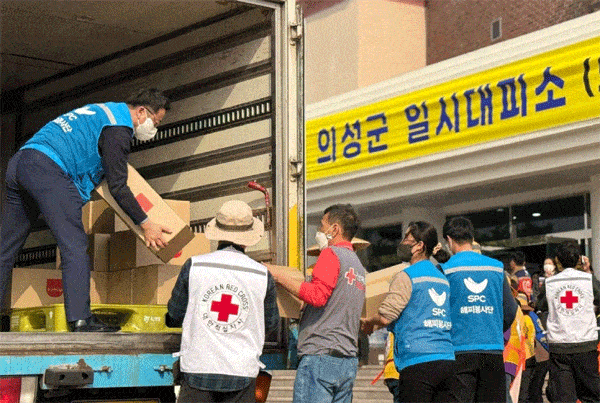 지난 24일 SPC해피봉사단원 등이 경북 의성군 산불 피해 이재민 일시대피소 앞에서 SPC그룹의 구호물품을 옮기고 있다./SPC그룹 제공 