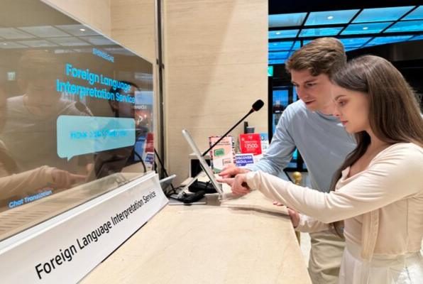 신세계백화점 본점을 방문한 외국인 고객들이 AI 기반 동시 통역 서비스를 이용하고 있다. [사진=신세계백화점]