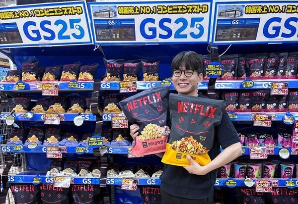 고객이 일본 돈키호테에 입점한 GS25의 넷플릭스 점보 팝콘을 들고 환하게 웃고 있다. [사진=GS리테일]