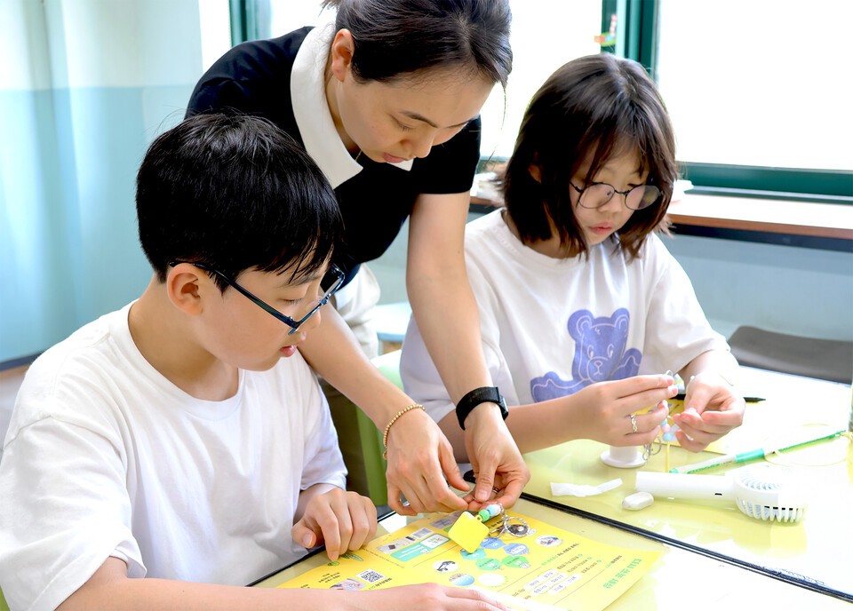 일일 선생님이 된 LG화학 임직원이 아이들과 폐플라스틱으로 키링 만들기 체험을 하고 있다./LG화학 제공
