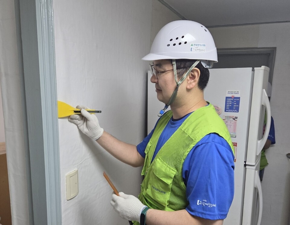 현대엔지니어링 집수리 봉사단이 서울시 노후주택에서 도배 작업을 하고 있다./현대엔지니어링 제공