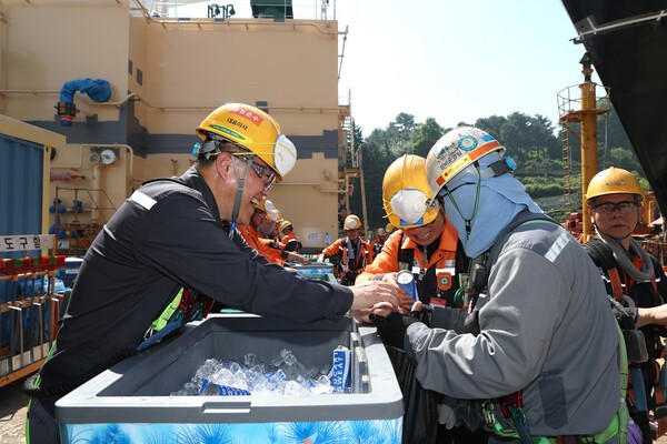 김희철 한화오션 대표이사(왼쪽)가 거제사업장 1도크 주변에서 근로자들에게 시원한 음료를 건네주고 있다./사진=한화오션