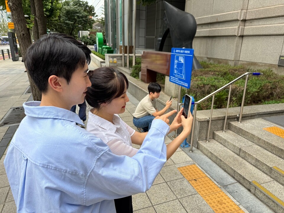 지난 14일 로드메이커 활동에 참여해 상업 시설의 계단, 경사로 등 접근성 정보를 기록하고 있는 SK이노베이션 계열 구성원들의 모습. /SK이노베이션 제공
