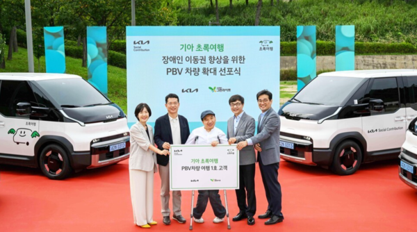 교통약자의 편리한 여행을 지원하는 사회공헌 프로그램 '초록여행'에 PV5 패신저 차량 8대를 신규 투입하는 기아. 사진은 이덕현 기아 지속가능경영실장 상무(왼쪽 두번째), 이재강 사단법인 그린라이트 회장(왼쪽 네번째) 등 주요 관계자들이 PV5 여행 1호 고객과 기념 촬영을 하고 있는 모습. /기아 제공