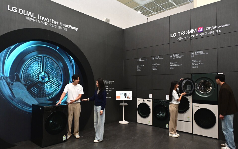 관람객들이 LG전자 부스에서 세탁물의 무게, 습도, 재질을 분석해 최적화된 맞춤 세탁건조하는 ‘AI DD 모터’가 탑재된 프리미엄 세탁·건조기를 살펴보고 있는 모습. /LG전자 제공