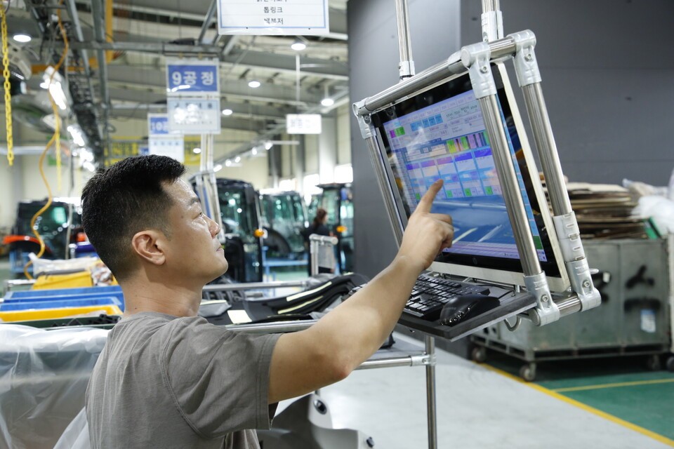 삼성의 스마트공장 지원을 통해 생산량 확대 및 페밀리 혁신을 이어가고 있는 전북 익산 농기계 제조업체 '위제스'. 사진은 위제스 직원이 관리 시스템을 통해 생산 공정을 제어하고 있는 모습. /삼성 제공