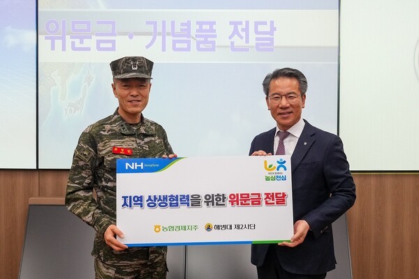 박서홍 농협경제지주 농업경제대표이사(오른쪽)가 지난 10일 해병대 제2사단에서 최영길 사단장(왼쪽)에게 지역 상생협력을 위한 위문금을 전달하고 있다./ 농협경제지주